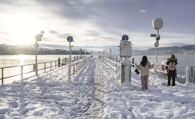 The snow-covered quay at Buerkliplatz on Lake Zurich on Friday, Nov. 22, 2024 in Zurich, Switzerland, as widespread snowfall from the evening before and during the night caused traffic disruptions in large parts of the Central Plateau. (Til Buergy/Keystone via AP)