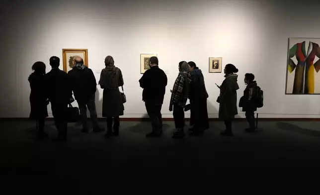 People visit an exhibition titled Eye to Eye which showcases over 120 works by modern world artists as well as Iranian painters at Tehran Museum of Contemporary Art, in Tehran, Thursday, Nov. 21, 2024. (AP Photo/Vahid Salemi)