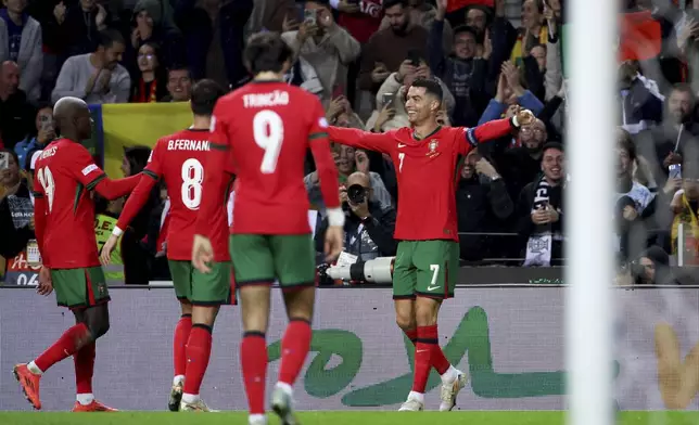 Portugal's Cristiano Ronaldo, right, celebrates after scoring his side's fifth goal during the UEFA Nations League soccer match between Portugal and Poland at the Dragao stadium in Porto, Portugal, Friday, Nov. 15, 2024. (AP Photo/Luis Vieira)