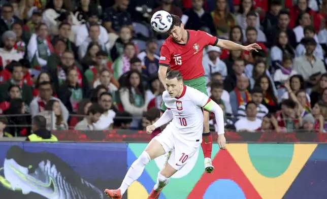 Portugal's Joao Neves heads the ball above Poland's Piotr Zielinski during the UEFA Nations League soccer match between Portugal and Poland at the Dragao stadium in Porto, Portugal, Friday, Nov. 15, 2024. (AP Photo/Luis Vieira)