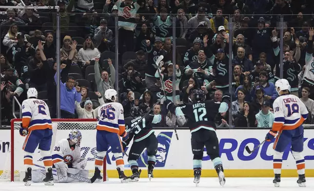 Fans react as Seattle Kraken center Yanni Gourde (37) scores against the New York Islanders during the first period of an NHL hockey game, Saturday, Nov. 16, 2024, in Seattle. (AP Photo/Rio Giancarlo)