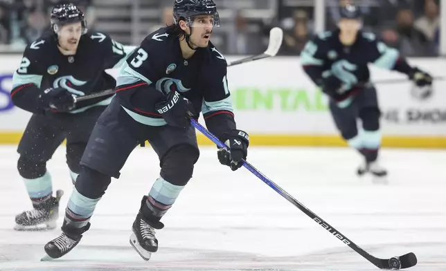 Seattle Kraken left wing Brandon Tanev (13) moves the puck against the New York Islanders during the second period of an NHL hockey game, Saturday, Nov. 16, 2024, in Seattle. (AP Photo/Rio Giancarlo)