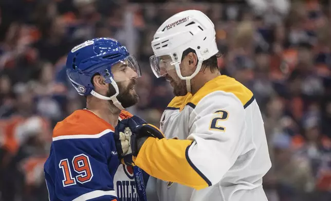 Nashville Predators' Luke Schenn (2) and Edmonton Oilers' Adam Henrique (19) have words during the second period of an NHL hockey game, Thursday, Nov. 14, 2024 in Edmonton, Alberta. (Jason Franson/The Canadian Press via AP)