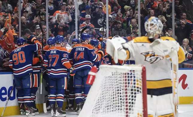 Edmonton Oilers' Connor McDavid (hidden) celebrates his 1000th point with teammates, against the Nashville Predators during the second period of an NHL hockey game, Thursday, Nov. 14, 2024 in Edmonton, Alberta. (Jason Franson/The Canadian Press via AP)