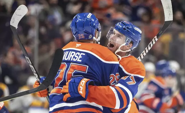 Edmonton Oilers' Darnell Nurse (25) and Connor McDavid (97) celebrate after their win over the Nashville Predators during overtime NHL hockey game action in Edmonton, Alberta, Thursday, Nov. 14, 2024. (Jason Franson/The Canadian Press via AP)