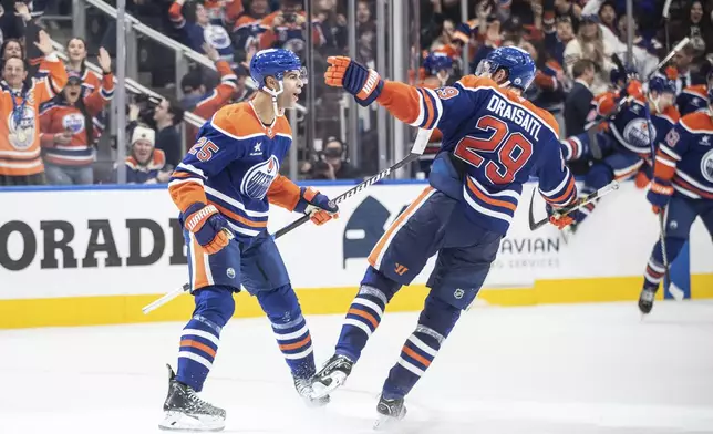 Edmonton Oilers' Darnell Nurse (25) and Leon Draisaitl (29) celebrate a goal against the Nashville Predators during overtime of an NHL hockey game, Thursday, Nov. 14, 2024 in Edmonton, Alberta. (Jason Franson/The Canadian Press via AP)