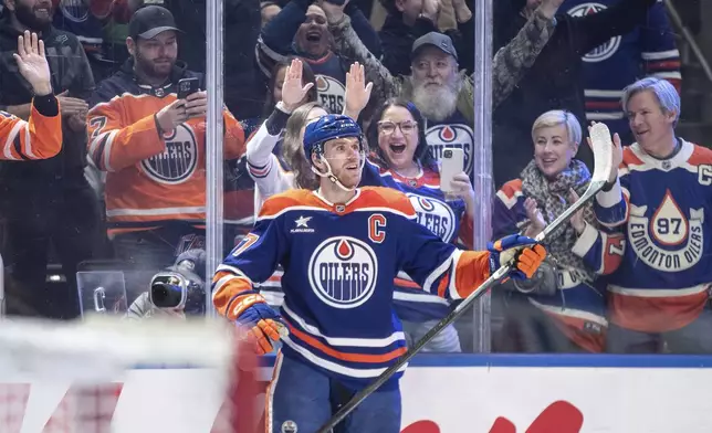 Edmonton Oilers' Connor McDavid (97) celebrates his 1000th point, against the Nashville Predators during the second period of an NHL hockey game, Thursday, Nov. 14, 2024 in Edmonton, Alberta. (Jason Franson/The Canadian Press via AP)