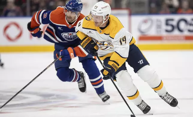 Nashville Predators' Gustav Nyquist (14) is chased by Edmonton Oilers' Evan Bouchard (2) during the first period of an NHL hockey game, Thursday, Nov. 14, 2024 in Edmonton, Alberta. (Jason Franson/The Canadian Press via AP)