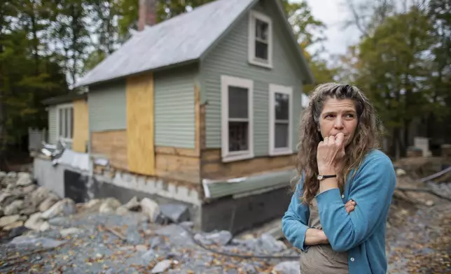 Jenny Mackenzie stands outside her flood-ravaged house in Peacham, Vt. on Sept. 23, 2024. (AP Photo/Dmitri Beliakov)