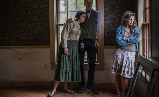 Lila, left, John and Jenny Mackenzie pose for a photo in their flood-damaged house in Peacham, Vt. on Sept. 23, 2024. (AP Photo/Dmitri Beliakov)