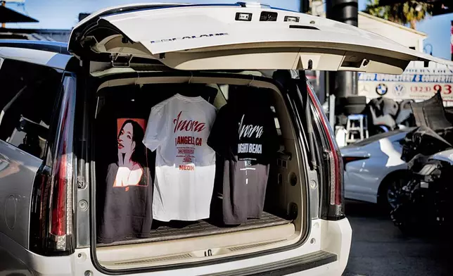 Tee shirts are displayed hanging in the back of a Cadillac Escalade during a merchandise Pop-Up event for the movie Anora on Saturday, Nov. 9, 2024 in Los Angeles. (AP Photo/Richard Vogel)