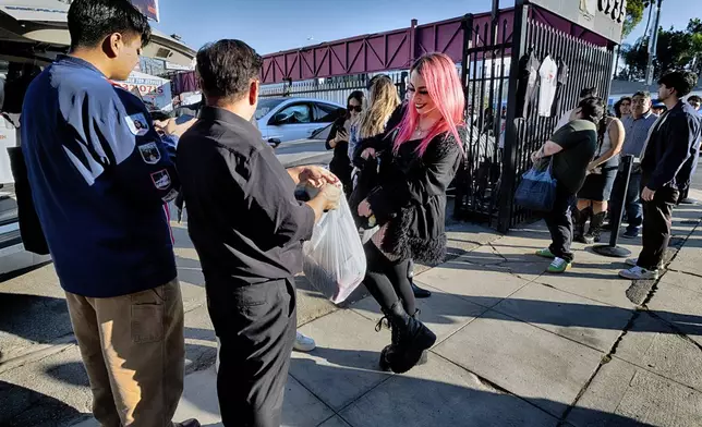 An Sabrina Bratt, movie fan receives her tee-shirts during a merchandise Pop-Up event for the newly released movie Anora on Saturday, Nov. 9, 2024 in Los Angeles. (AP Photo/Richard Vogel)