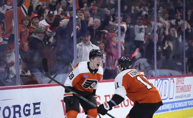 Philadelphia Flyers' Matvei Michkov, left, and Travis Konecny celebrate after Michkov scored the game-winning goal during overtime in an NHL hockey game against the Chicago Blackhawks, Saturday, Nov. 23, 2024, in Philadelphia. (AP Photo/Matt Slocum)