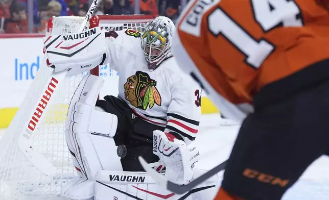 Chicago Blackhawks' Petr Mrazek, left, blocks a shot by Philadelphia Flyers' Sean Couturier during the second period of an NHL hockey game, Saturday, Nov. 23, 2024, in Philadelphia. (AP Photo/Matt Slocum)