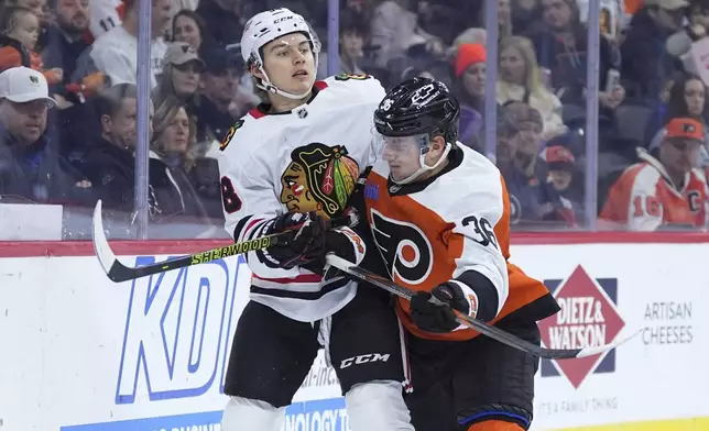 Chicago Blackhawks' Connor Bedard, left, and Philadelphia Flyers' Emil Andrae collide during the first period of an NHL hockey game, Saturday, Nov. 23, 2024, in Philadelphia. (AP Photo/Matt Slocum)