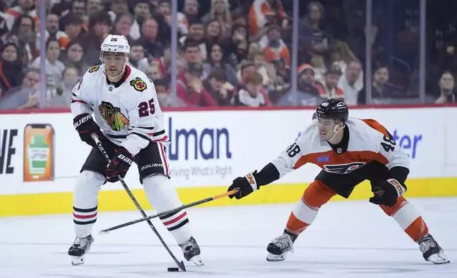 Chicago Blackhawks' Alec Martinez, left, tries to get past Philadelphia Flyers' Morgan Frost during the third period of an NHL hockey game, Saturday, Nov. 23, 2024, in Philadelphia. (AP Photo/Matt Slocum)