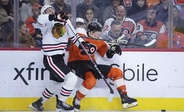 Chicago Blackhawks' Jason Dickinson, left, and Philadelphia Flyers' Nick Seeler collide during the third period of an NHL hockey game, Saturday, Nov. 23, 2024, in Philadelphia. (AP Photo/Matt Slocum)