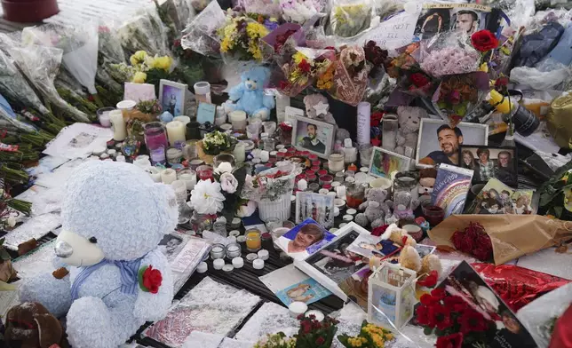 Flowers, portraits and toys lay in the ground for memory of the One Direction star singer Liam Payne at a memorial in West Park in his hometown of Wolverhampton, England, Wednesday, Nov. 20, 2024. (Jacob King/PA via AP)