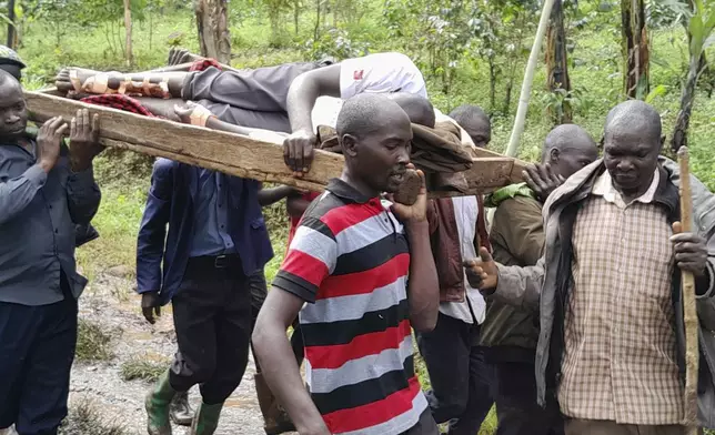 Rescue workers carry an injured man after landslides following heavy rains buried 40 homes in the mountainous district of Bulambuli, eastern Uganda, Thursday, Nov. 28. 2024. (AP Photo/Jean Watala)