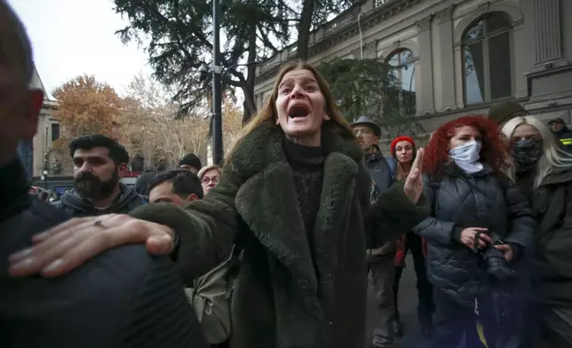 A woman shouts standing in front of police blocking the entrance of the Parliament's building during a rally to demand new parliamentary elections in the country, in Tbilisi, Georgia, on Monday, Nov. 25, 2024. (AP Photo/Zurab Tsertsvadze)