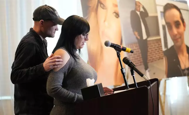 Ashtin Gamblin, survivor of the Club Q nightclub mass shooting in Colorado Springs, Colo., is consoled by her husband Robert Conner Jr., during a news conference announcing the filing of a civil complaint on the two-year anniversary of the deadly mass shooting, Tuesday, Nov. 19, 2024, in Denver. (AP Photo/Jack Dempsey)