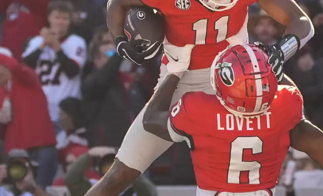 Georgia wide receiver Arian Smith (11) celebrates with Dominic Lovett (6) after a touchdown catch during the first half of an NCAA college football game against UMass, Saturday, Nov. 23, 2024, in Athens, Ga. (AP Photo/John Bazemore)