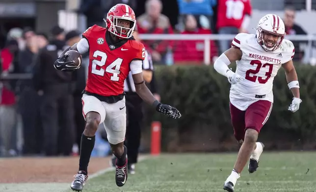 Georgia defensive back Malaki Starks (24) is chased by UMass linebacker Jalen Stewart (23) as he returns a punt during the second half of an NCAA college football game, Saturday, Nov. 23, 2024, in Athens, Ga. (AP Photo/John Bazemore)