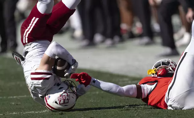 UMass wide receiver Sterling Galban (4) falls after a catch as Georgia defensive back Daniel Harris (7) defends during the first half of an NCAA college football game, Saturday, Nov. 23, 2024, in Athens, Ga. (AP Photo/John Bazemore)