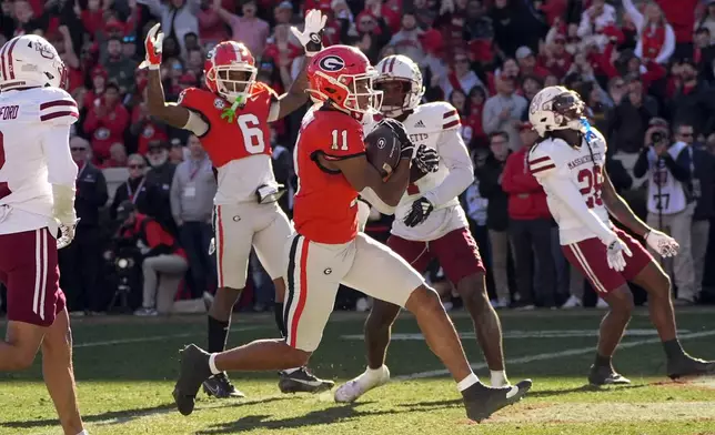 Georgia wide receiver Arian Smith (11) runs in for a touchdown after a catch as UMass defensive back Lake Ellis (7) looks on during the first half of an NCAA college football game, Saturday, Nov. 23, 2024, in Athens, Ga. (AP Photo/John Bazemore)