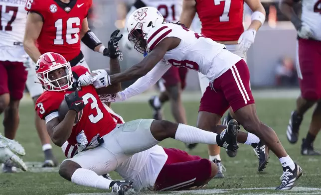 Georgia running back Nate Frazier (3) is stopped by UMass cornerback Jerrod Cameron (28) during the second half of an NCAA college football game, Saturday, Nov. 23, 2024, in Athens, Ga. (AP Photo/John Bazemore)