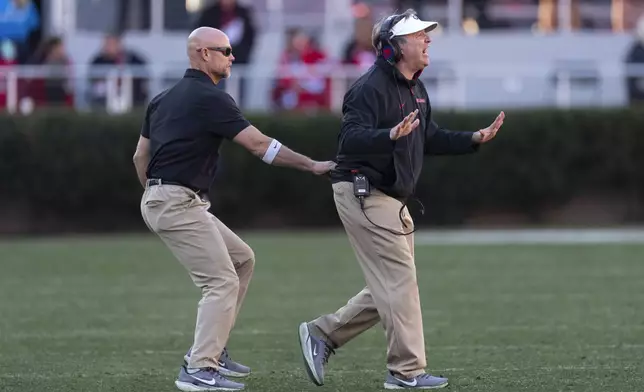 Georgia head coach Kirby Smart, right, is restrained by an assistant as he yells instructions to his players on the field during the second half of an NCAA college football game against UMass, Saturday, Nov. 23, 2024, in Athens, Ga. (AP Photo/John Bazemore)