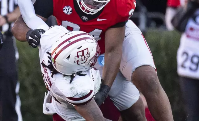 UMass quarterback AJ Hairston (8) fumbles as he is hit by Georgia defensive lineman Xzavier McLeod (94) during the second half of an NCAA college football game, Saturday, Nov. 23, 2024, in Athens, Ga. (AP Photo/John Bazemore)