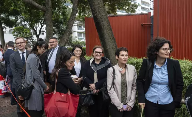 Representatives from various consulates wait in line outside the West Kowloon Magistrates' Courts in Hong Kong Tuesday, Nov. 19, 2024, ahead of the sentencing in national security case. (AP Photo/Chan Long Hei)