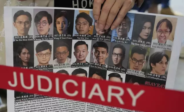 FILE - A supporter holds a placard with the photos of some of the 47 pro-democracy defendants outside a court in Hong Kong, on July 8, 2021. (AP Photo/Kin Cheung, File)