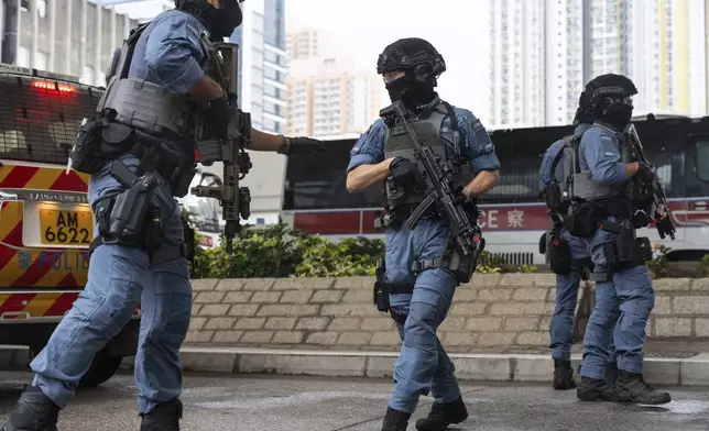 Armed police officers stand guard outside the West Kowloon Magistrates' Courts in Hong Kong Tuesday, Nov. 19, 2024. (AP Photo/Chan Long Hei)