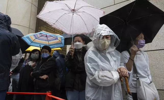 People wait outside the West Kowloon Magistrates' Courts in Hong Kong Tuesday, Nov. 19, 2024, ahead of the sentencing in national security case. (AP Photo/Chan Long Hei)