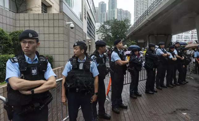 Police officers stand guard outside the West Kowloon Magistrates' Courts in Hong Kong, Tuesday, Nov. 19, 2024. (AP Photo/Chan Long Hei)