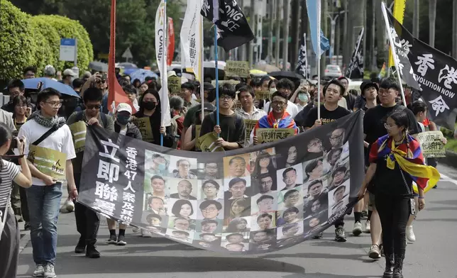 FILE- Hong Kong activists and supporters march with a banner which reads " Unite now in solidarity with the Hong Kong 47 and other political prisoners" during a protest commemorating the 10th anniversary of the 2014 umbrella movement and the fifth anniversary of the anti-extradition law amendment bill movement in Taipei, Taiwan, June 9, 2024. (AP Photo/Chiang Ying-ying, File)