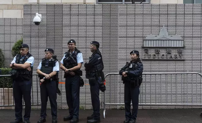 Police officers stand guard outside the West Kowloon Magistrates' Courts in Hong Kong Tuesday, Nov. 19, 2024. (AP Photo/Chan Long Hei)