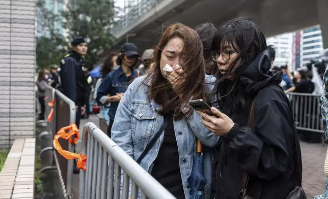 People leave the West Kowloon Magistrates' Courts in Hong Kong Tuesday, Nov. 19, 2024, following the sentencing in national security case. (AP Photo/Chan Long Hei)