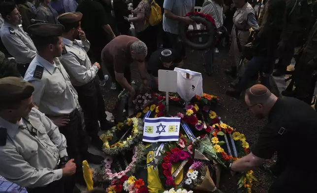 Mourners gather around the grave of Israeli soldier Capt. Itay Marcovich, who was killed in action in Lebanon, during his funeral in Kokhav Yair, Israel, Thursday, Nov. 14, 2024. (AP Photo/Ohad Zwigenberg)