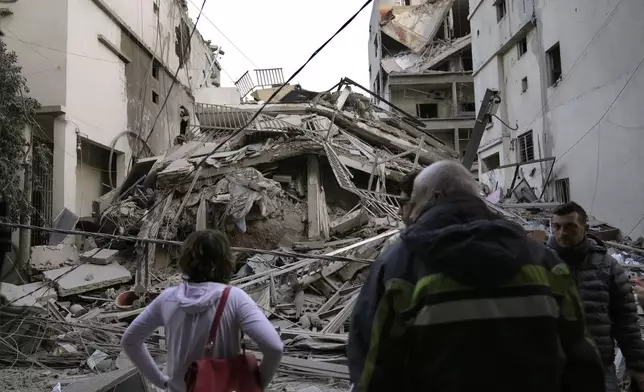 Residents check their destroyed building hit in an Israeli airstrike in Dahiyeh, in the southern suburb of Beirut, Lebanon, Thursday, Nov. 14, 2024. (AP Photo/Hussein Malla)