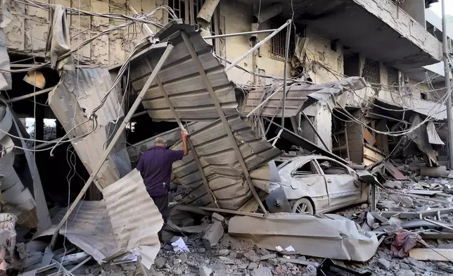 A man checks his destroyed shop at a street that was hit in an Israeli airstrike in Dahiyeh, in the southern suburb of Beirut, Lebanon, Thursday, Nov. 14, 2024. (AP Photo/Hussein Malla)