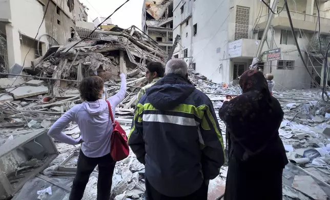 Residents check their destroyed building hit in an Israeli airstrike in Dahiyeh, in the southern suburb of Beirut, Lebanon, Thursday, Nov. 14, 2024. (AP Photo/Hussein Malla)