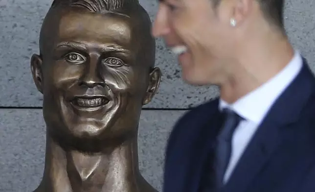 FILE - Real Madrid's Cristiano Ronaldo stands next to a bust of himself at the Madeira international airport outside Funchal, the capital of Madeira island, Portugal, Wednesday March 29, 2017. (AP Photo/Armando Franca, File)