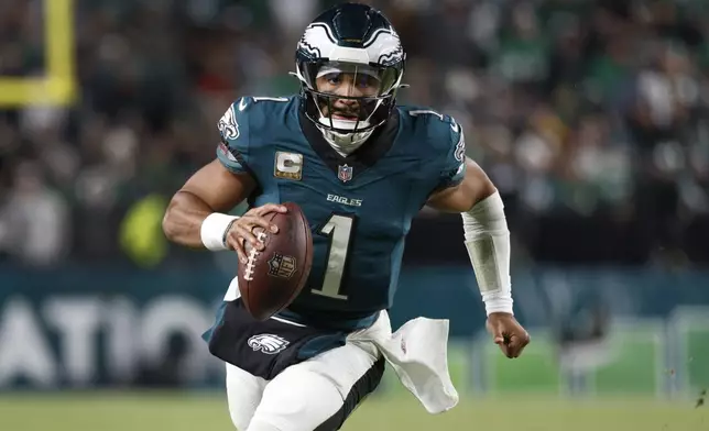 Philadelphia Eagles quarterback Jalen Hurts (1) runs with the ball during the second half of an NFL football game against the Washington Commanders Thursday, Nov. 14, 2024, in Philadelphia. (AP Photo/Laurence Kesterson)