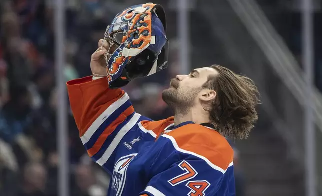 Edmonton Oilers goalie Stuart Skinner (74) puts his mask on before taking on the New York Rangers during first period NHL action in Edmonton on Saturday, November 23, 2024. (Jason Franson/The Canadian Press via AP)