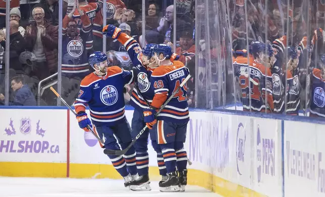 Edmonton Oilers' Brett Kulak (27), Vasily Podkolzin (92) and Ty Emberson (49) celebrate a goal against the New York Rangers during first period NHL action in Edmonton on Saturday, November 23, 2024. (Jason Franson/The Canadian Press via AP)