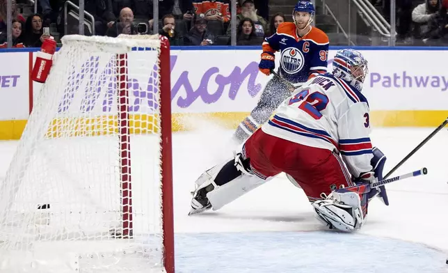 New York Rangers' goalie Jonathan Quick (32) is scored on as Edmonton Oilers' Connor McDavid (97) watches the puck go in the net during second period NHL action in Edmonton on Saturday, November 23, 2024. (Jason Franson/The Canadian Press via AP)