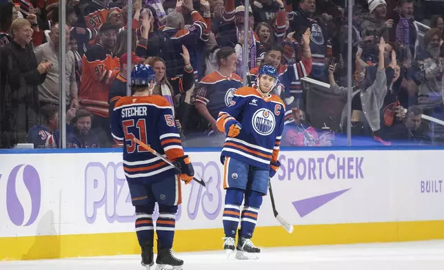 Edmonton Oilers' Troy Stecher (51) and Connor McDavid (97) celebrate a goal against the New York Rangers during the third period of an NHL hockey game in Edmonton, Alberta, Saturday, Nov. 23, 2024. (Jason Franson/The Canadian Press via AP)